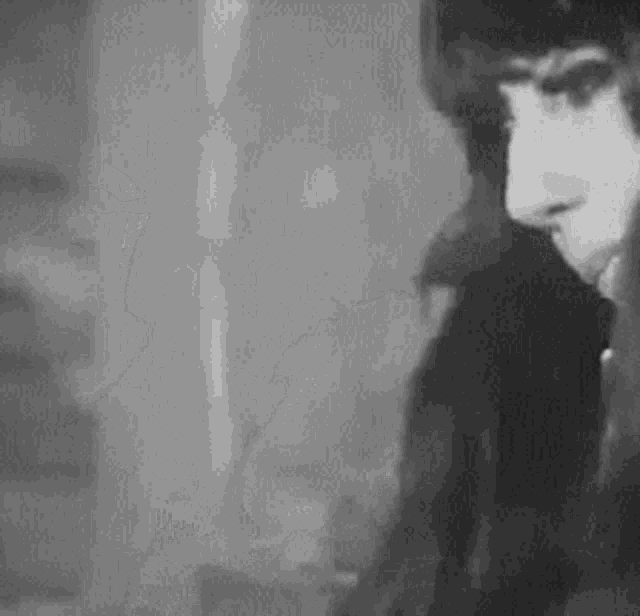 a black and white photo of a man 's face in a room .