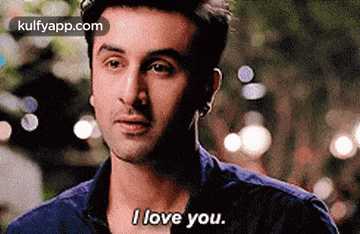 a man is saying i love you while looking at the camera .