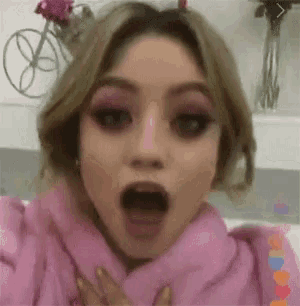 a close up of a woman 's face with her mouth open and a surprised look on her face .
