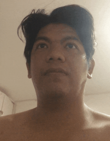 a man without a shirt looks up at something