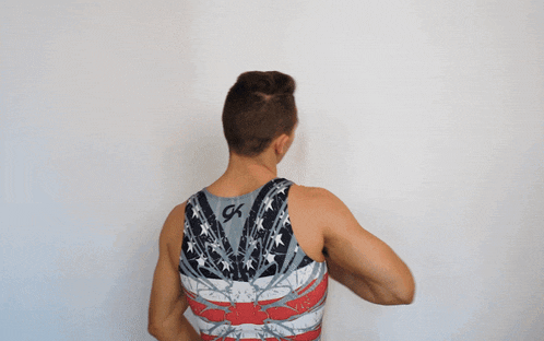 a man wearing an american flag tank top has the letter ck on the back
