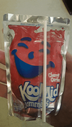 a person is holding a bag of kool aid cherry creme with a straw