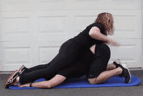 a man and a woman are doing exercises on a blue mat .