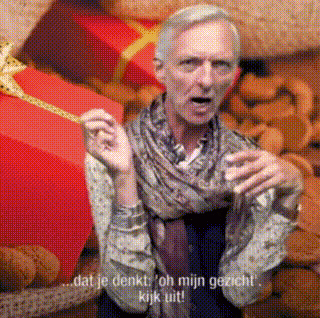 a man in a scarf stands in front of a pile of teddy bears and says " dat je denkt "