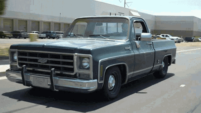 a green chevy truck is parked in front of a building with the number 1234 on it