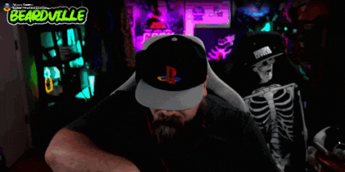 a bearded man wearing a playstation hat is eating