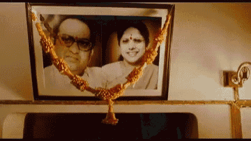 a framed picture of a man and woman with a gold garland around them