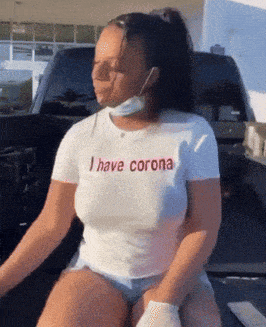 a woman wearing a mask and a t-shirt that says " i have corona "