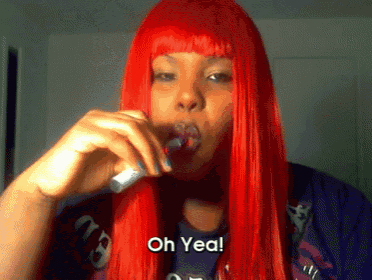 a woman with red hair says " oh yea " while holding a lollipop