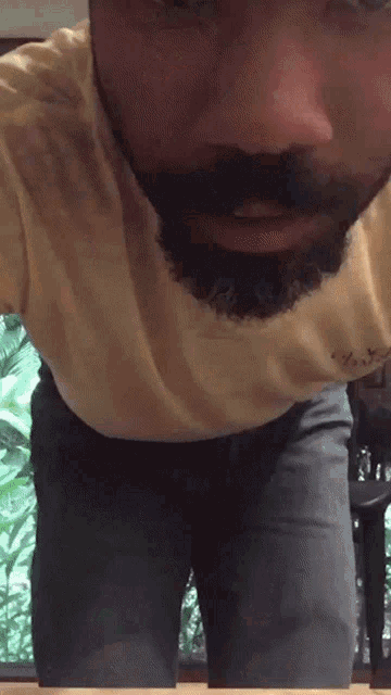 a man with a beard is wearing a yellow shirt