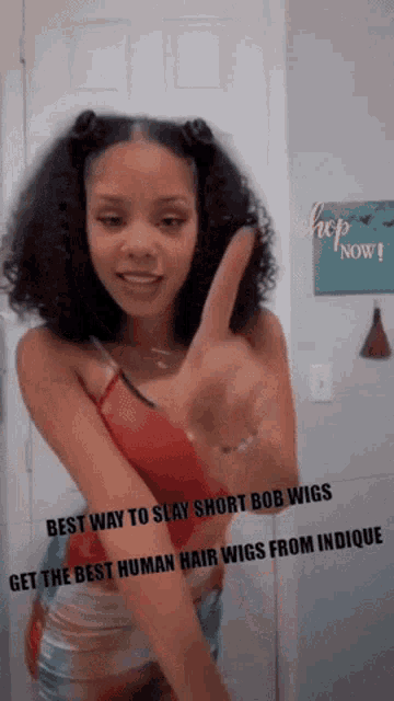 a woman in a red top is giving a peace sign