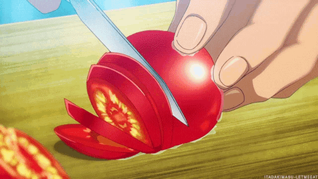 a person is cutting a tomato in half with a knife