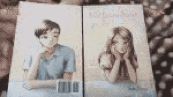 a man and a woman are sitting next to each other on a book .