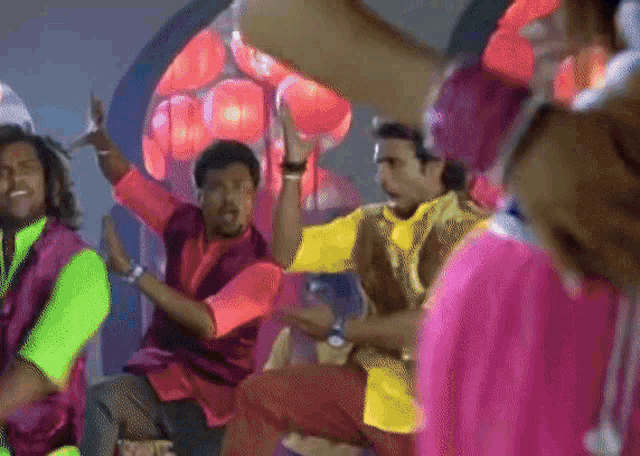 a group of men are dancing in a room with a bunch of lanterns in the background