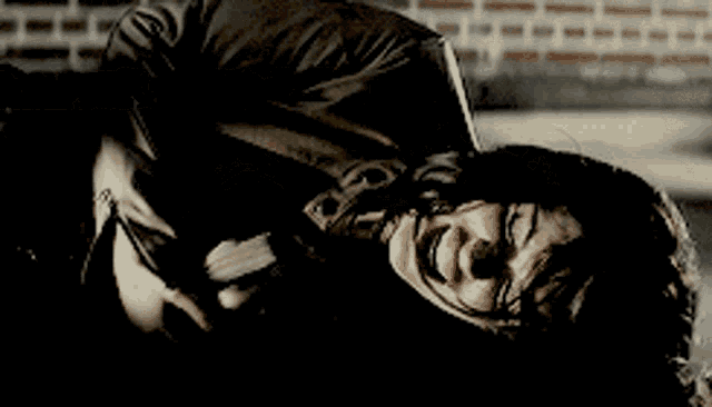 a person is laying on their back with a brick wall behind them