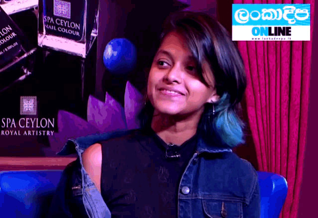 a girl with blue hair is smiling in front of a sign that says spa ceylon