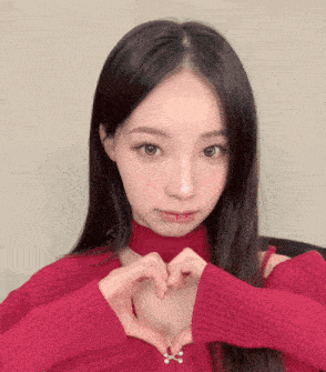 a woman making a heart shape with her hands