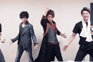 a group of young men are standing next to each other dancing in a room .