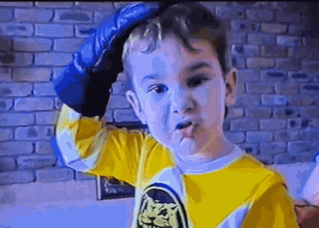 a young boy wearing a yellow and white shirt with a cat on it