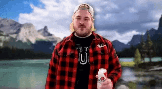 a man wearing a plaid shirt with the letter u on the front