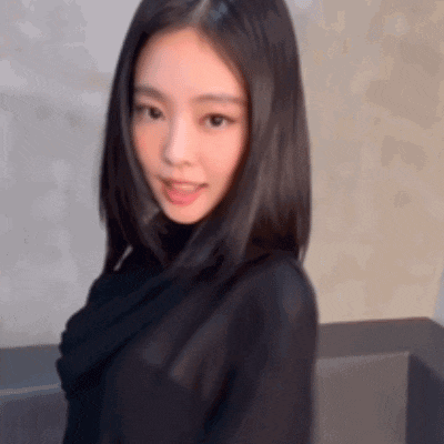 a young woman with long black hair is wearing a black turtleneck sweater and looking at the camera .