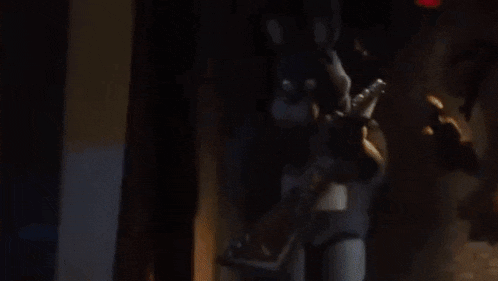 a person is holding a stuffed animal in their hands in a dark room .