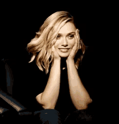 a woman with her hands on her face is sitting in a chair