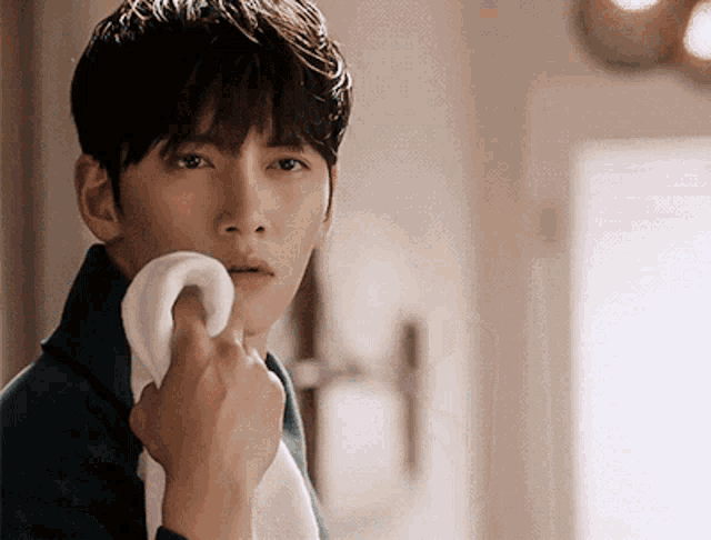 a man wipes his face with a towel