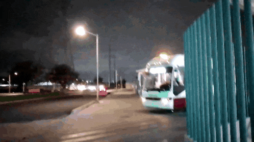 a blurry picture of a street at night with a bus in the background