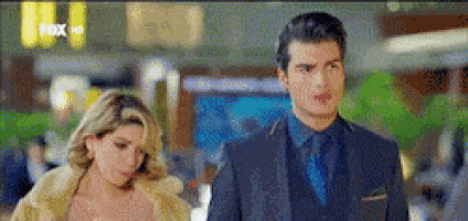 a man and a woman are standing next to each other in a mall .