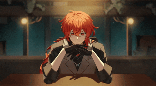 a man with red hair and black gloves sits at a table with his hands folded