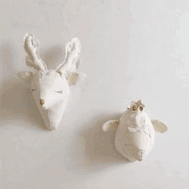 a group of stuffed reindeer standing next to each other on a snowy surface .