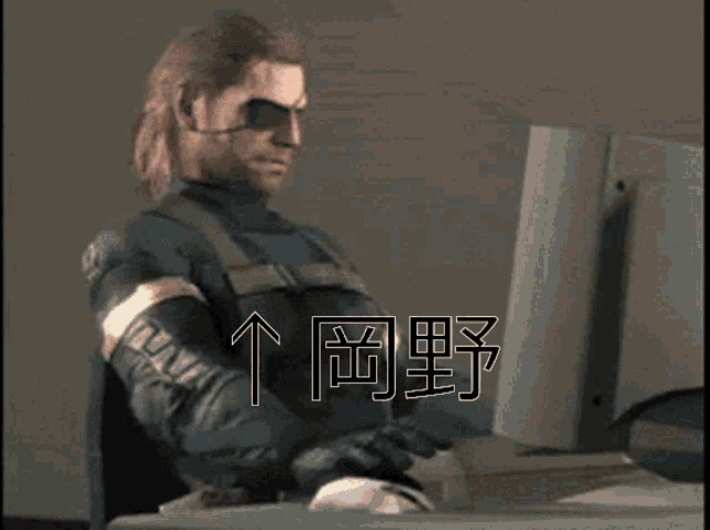 a man sitting in front of a computer with chinese characters on the screen