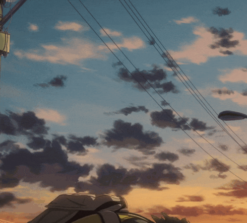 a sunset with a street light in the foreground and a telephone pole in the background