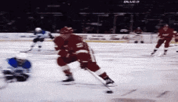 a hockey game is being played in front of a banner that says blue's