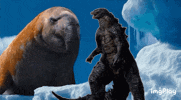 a seal and a monster are standing next to each other in the snow ..