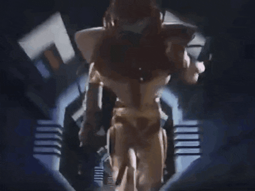 a robot is standing in a dark room with a glowing light behind it
