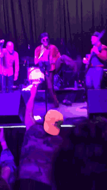 a man in a white hat is taking a picture of a band on a stage