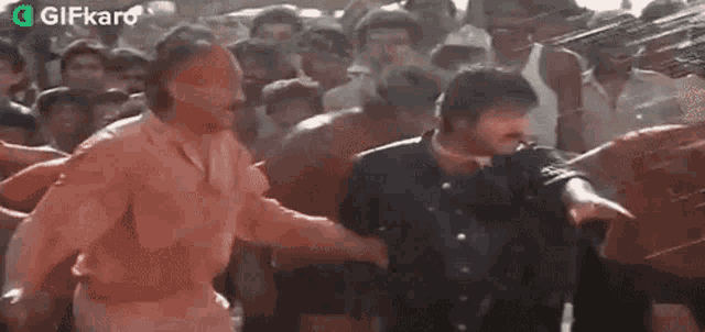 a group of people are standing in the rain and a man is being sprayed with water .