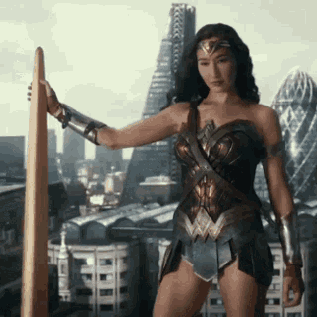 a woman in a wonder woman costume is holding a sword