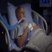 a woman is laying in a hospital bed with an oxygen mask around her mouth