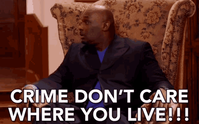 a man in a suit is sitting in a chair and saying " crime don 't care where you live !!! "
