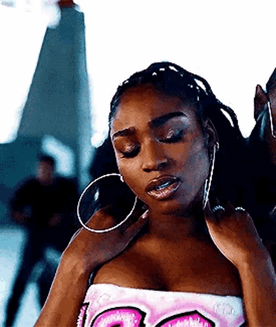 a woman wearing hoop earrings and a strapless top is being touched by a man .