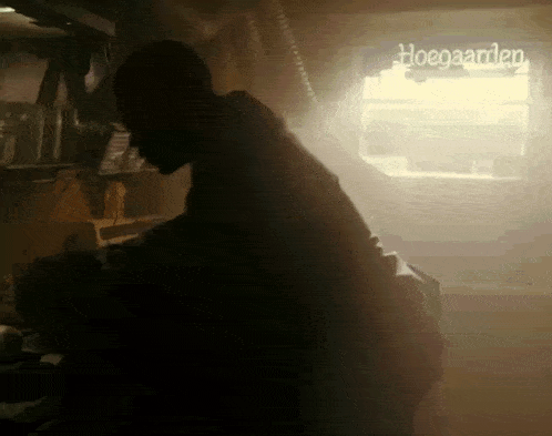 a silhouette of a man standing in front of a sign that says hoegaarden