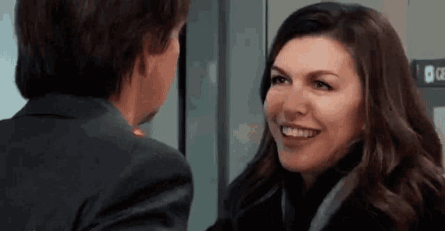 a man and a woman are smiling at each other .