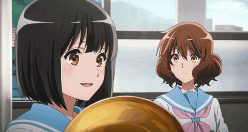 two anime girls are standing next to each other and one is holding a gold object