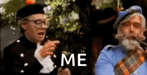 two men are standing next to each other and one of them is pointing at the other while the other man says `` me '' .