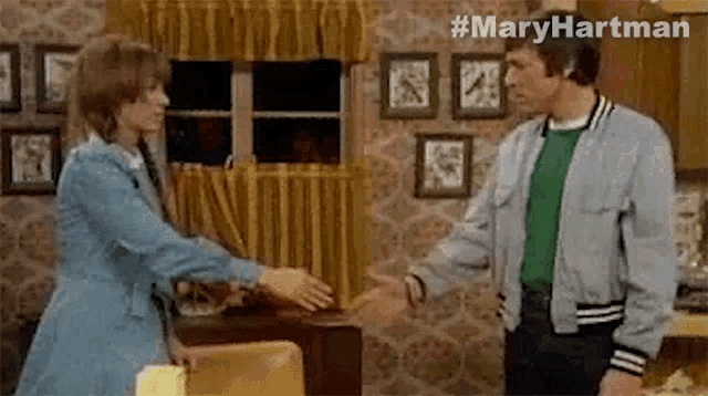 a man and a woman are holding hands in a living room .