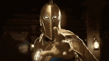 a man in a knight 's helmet is pointing at the camera .