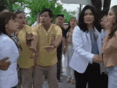 a group of people are standing in a line with one woman wearing a yellow shirt that says ' nurse ' on it